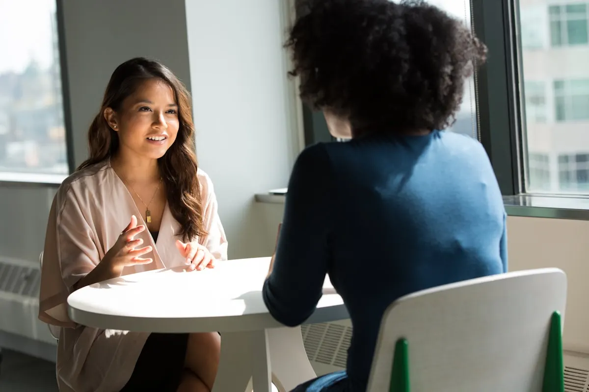 Two people in conversation across a table — illustrative photograph